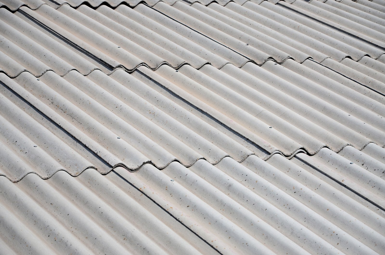 A fragment of a gray slate roof of an old sample made of asbestos material